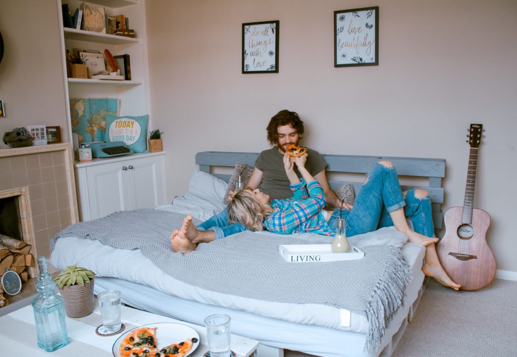 A couple cuddling up on a bed